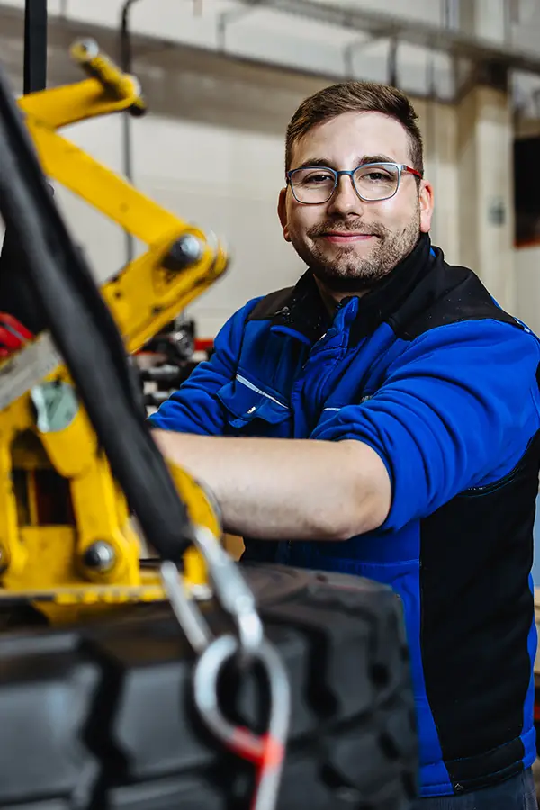 Auszubildender an einer Maschine in der Werkstatt