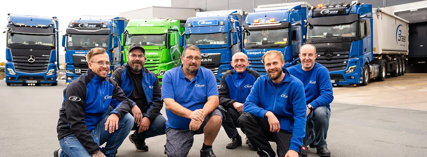 Fahrerteam der BrassGruppe vor den LKW